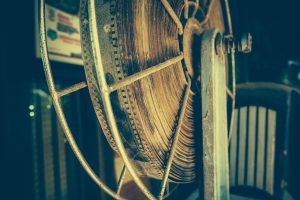 An old fashioned age-damaged film reel on a metallic spindle.